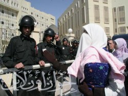 إحدى زوجات المعتقلين تحمل رضيعها في انتظار رؤية زوجها