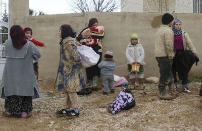 مساعدات تصل حمص وسوريون يفرون إلى الحدود