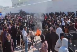 محررون بغزة يحرقون ملابس أجبرهم الاحتلال على ارتدائها